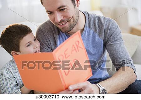 Father and son (8-9) looking at greeting card View Large Photo Image Stock Image - Father and son (8-9) looking at greeting card. Fotosearch