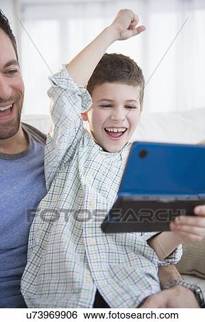 Father and son (8-9) playing video game View Large Photo Image Stock Photograph - Father and son (8-9) playing video game . Fotosearch