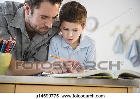 Stock Photography - Father helping his son (8-9) with homework. Fotosearch