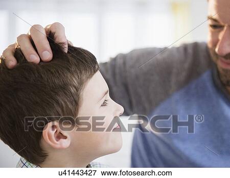 Stock Photo - Father looking after son (8-9). Fotosearch