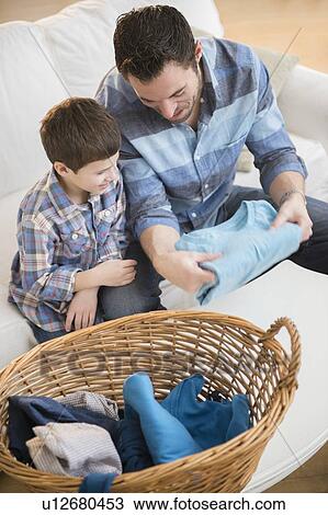 Father sorting laundry with his son (8-9) View Large Photo Image Stock Image - Father sorting laundry with his son (8-9) . Fotosearch