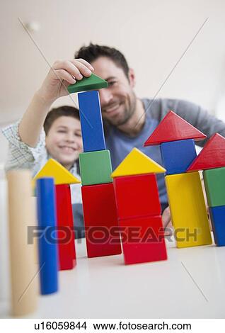 Father stacking blocks with his son (8-9) View Large Photo Image Picture - Father stacking blocks with his son (8-9) . Fotosearch