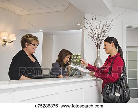 Female patient at doctor's office front desk View Large Photo Image Stock Photograph - Female patient at doctor's office front desk. Fotosearch