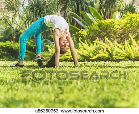 Stock Image - girl ( 8-9) doing back bend. Fotosearch