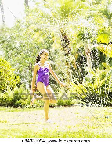girl (8-9) playing in sprinkler View Large Photo Image Picture - girl (8-9) playing in sprinkler. Fotosearch
