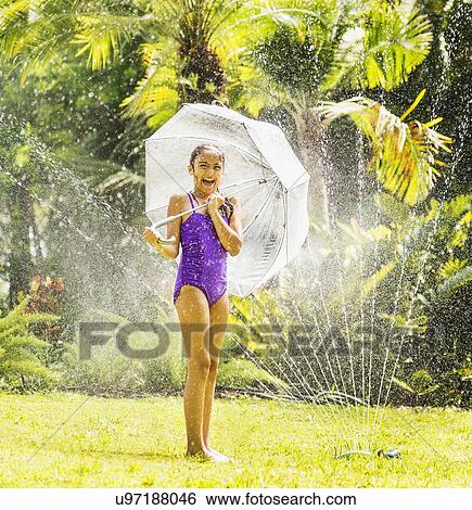 girl (8-9) playing in sprinkler View Large Photo Image Stock Photograph - girl (8-9) playing in sprinkler. Fotosearch
