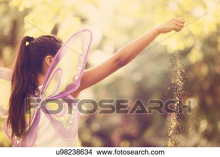 Picture - girl (8-9) spreading fairy dust. Fotosearch