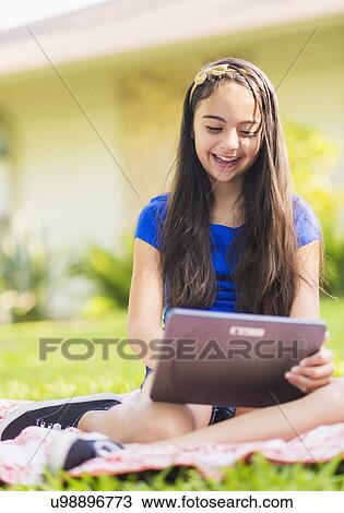 Stock Image - girl ( 8-9) using digital tablet . Fotosearch