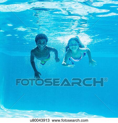 Stock Image - Girl and boy ( 6-7, 8-9) swimming. Fotosearch