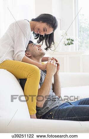 Happy young couple playing on sofa View Large Photo Image Stock Image - Happy young couple playing on sofa. Fotosearch