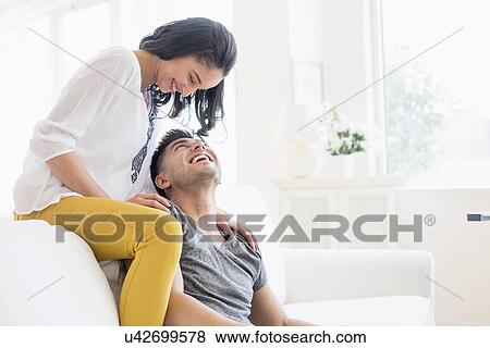 Happy young couple playing on sofa View Large Photo Image Stock Photo - Happy young couple playing on sofa. Fotosearch