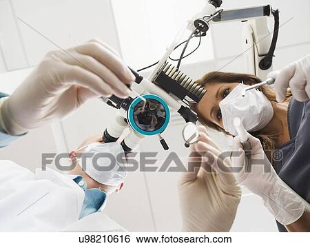Lowe angle view of dentist and assistant View Large Photo Image Stock Photograph - Lowe angle view of dentist and assistant. Fotosearch