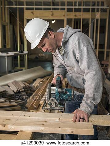 Stock Photo - Lumber at work on new structure. Fotosearch