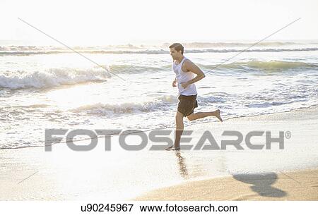 Man running on beach View Large Photo Image Stock Photo - Man running on beach. Fotosearch