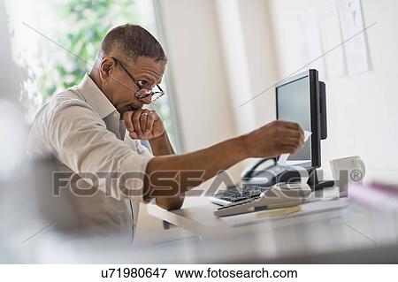 Mature man working in home office View Large Photo Image Stock Photo - Mature man working in home office. Fotosearch