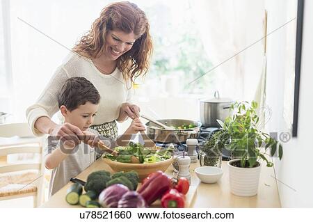 Mother and son (6-7) cooking together View Large Photo Image Stock Image - Mother and son (6-7) cooking together. Fotosearch