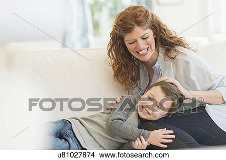Mother and son (6-7) relaxing on sofa View Large Photo Image Picture - Mother and son (6-7) relaxing on sofa. Fotosearch
