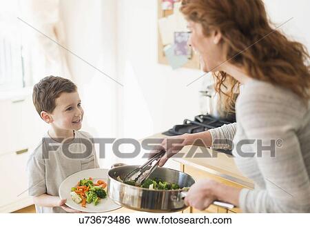 Mother and son (6-7) serving healthy dinner View Large Photo Image Stock Photograph - Mother and son (6-7) serving healthy dinner. Fotosearch