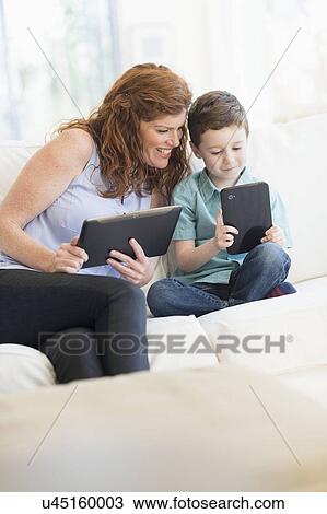 Stock Image - Mother and son (6-7) using digital tablets. Fotosearch