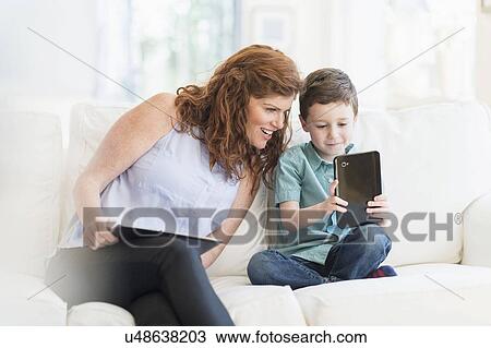 Stock Image - Mother and son (6-7) using digital tablet. Fotosearch