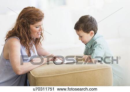 Stock Image - Mother and son (6-7) using digital tablet. Fotosearch