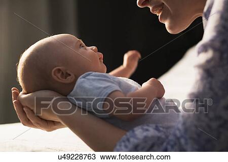 Mother holding baby boy (2-5 months) in bedroom View Large Photo Image Stock Image - Mother holding baby boy (2-5 months) in bedroom. Fotosearch