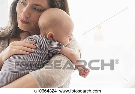 Picture - Mother holding baby boy (2-5 months) on her arm. Fotosearch