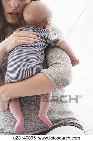 Stock Photography - Mother holding baby boy (2-5 months) on her arm. Fotosearch