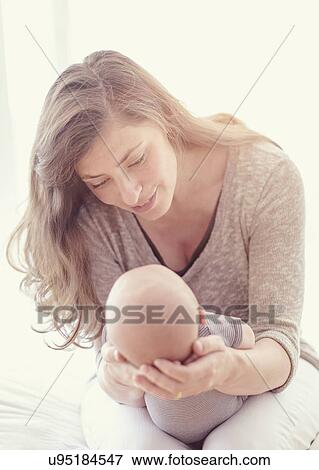 Stock Photo - Mother holding baby boy (2-5 months). Fotosearch