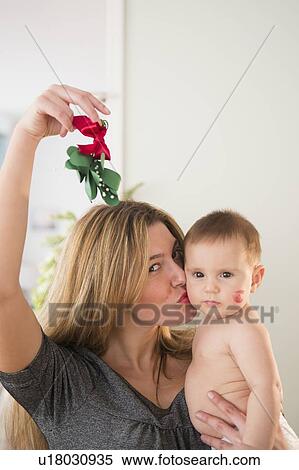 Mother holding baby girl (6-11 months) and mistletoe View Large Photo Image Stock Photography - Mother holding baby girl (6-11 months) and mistletoe. Fotosearch