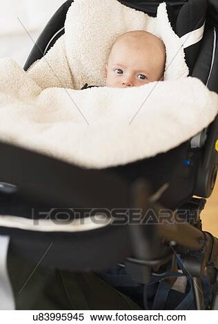 Stock Photography - Portrait of baby boy (2-5 months) sitting in stroller. Fotosearch
