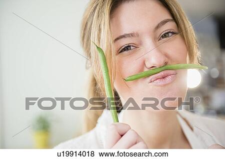 Portrait of blond woman holding green beans View Large Photo Image Stock Photo - Portrait of blond woman holding green beans. Fotosearch