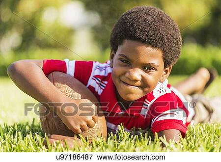Stock Photo - Portrait of boy (6-7) with ball. Fotosearch