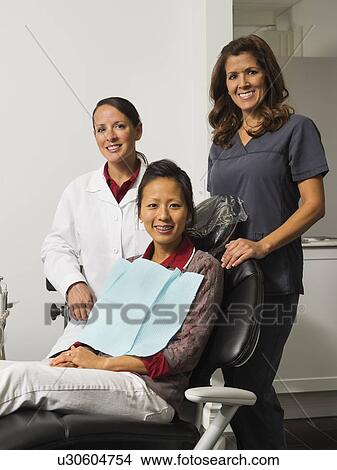 Portrait of dentist with patient and assistant View Large Photo Image Picture - Portrait of dentist with patient and assistant. Fotosearch