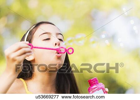 Portrait of girl (8-9) blowing bubbles View Large Photo Image Stock Photo - Portrait of girl (8-9) blowing bubbles. Fotosearch
