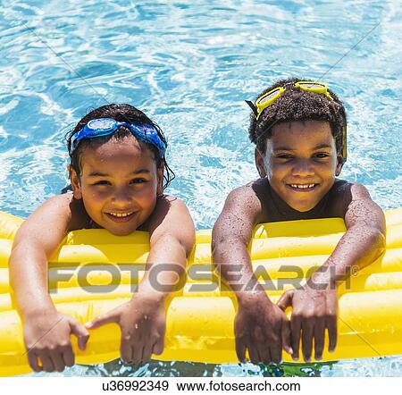 Stock Photo - Portrait of kids( 6-7, 8-9) with pool raft. Fotosearch