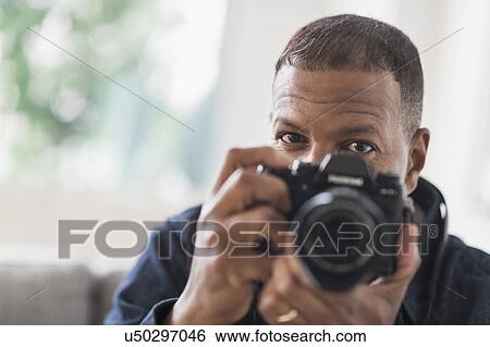 Portrait of man holding digital camera View Large Photo Image Stock Photograph - Portrait of man holding digital camera. Fotosearch