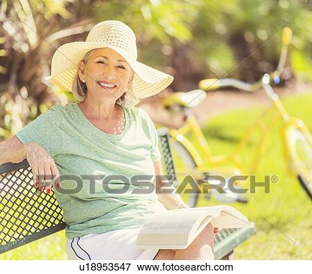 Portrait of senior woman reading book in park View Large Photo Image Stock Photo - Portrait of senior woman reading book in park. Fotosearch
