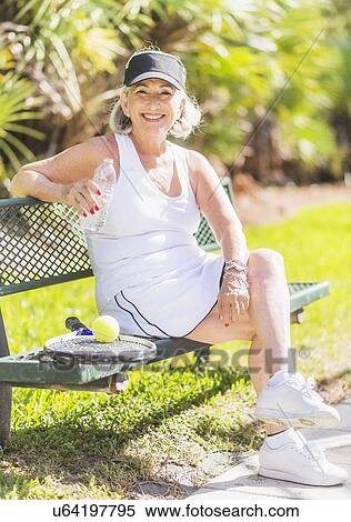 Portrait of senior woman sitting on bench View Large Photo Image Stock Photography - Portrait of senior woman sitting on bench. Fotosearch