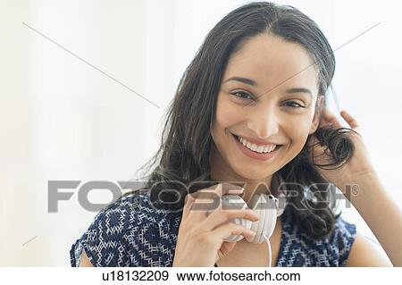 Stock Photo - Portrait of smiling young woman with headphones. Fotosearch