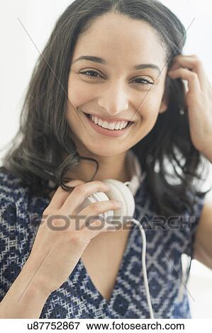 Stock Photo - Portrait of smiling young woman with headphones. Fotosearch
