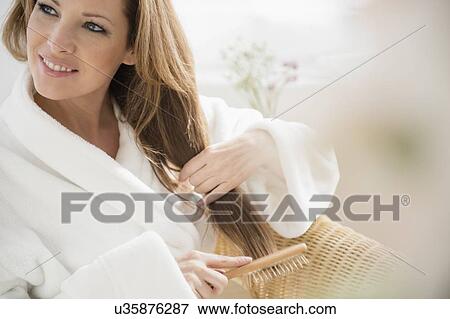 Stock Photo - Portrait of woman brushing hair. Fotosearch