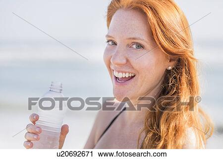 Portrait of woman drinking water on beach View Large Photo Image Stock Image - Portrait of woman drinking water on beach. Fotosearch
