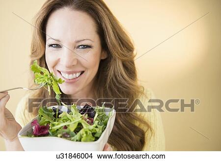 Picture - Portrait of woman eating salad. Fotosearch