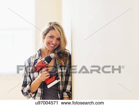 Portrait of woman holding drill View Large Photo Image Stock Image - Portrait of woman holding drill. Fotosearch