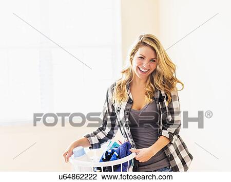 Portrait of woman holding laundry basket View Large Photo Image Stock Image - Portrait of woman holding laundry basket. Fotosearch