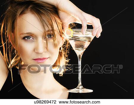 Portrait of woman holding martini glass View Large Photo Image Stock Image - Portrait of woman holding martini glass. Fotosearch
