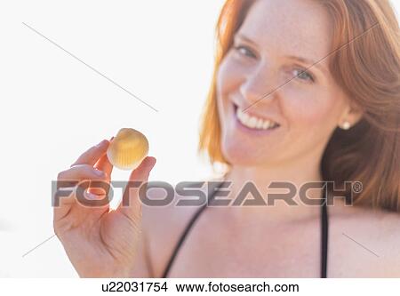 Picture - Portrait of woman holding shell. Fotosearch