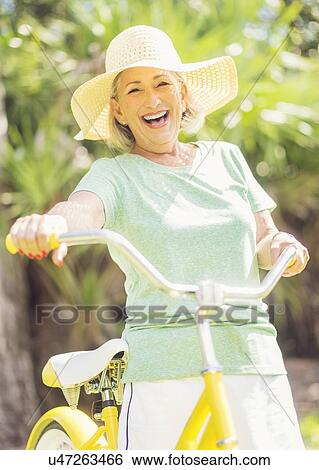 Stock Photograph - Portrait of woman on bicycle. Fotosearch