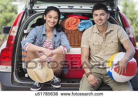 Portrait of young couple sitting in open car trunk View Large Photo Image Stock Photo - Portrait of young couple sitting in open car trunk. Fotosearch